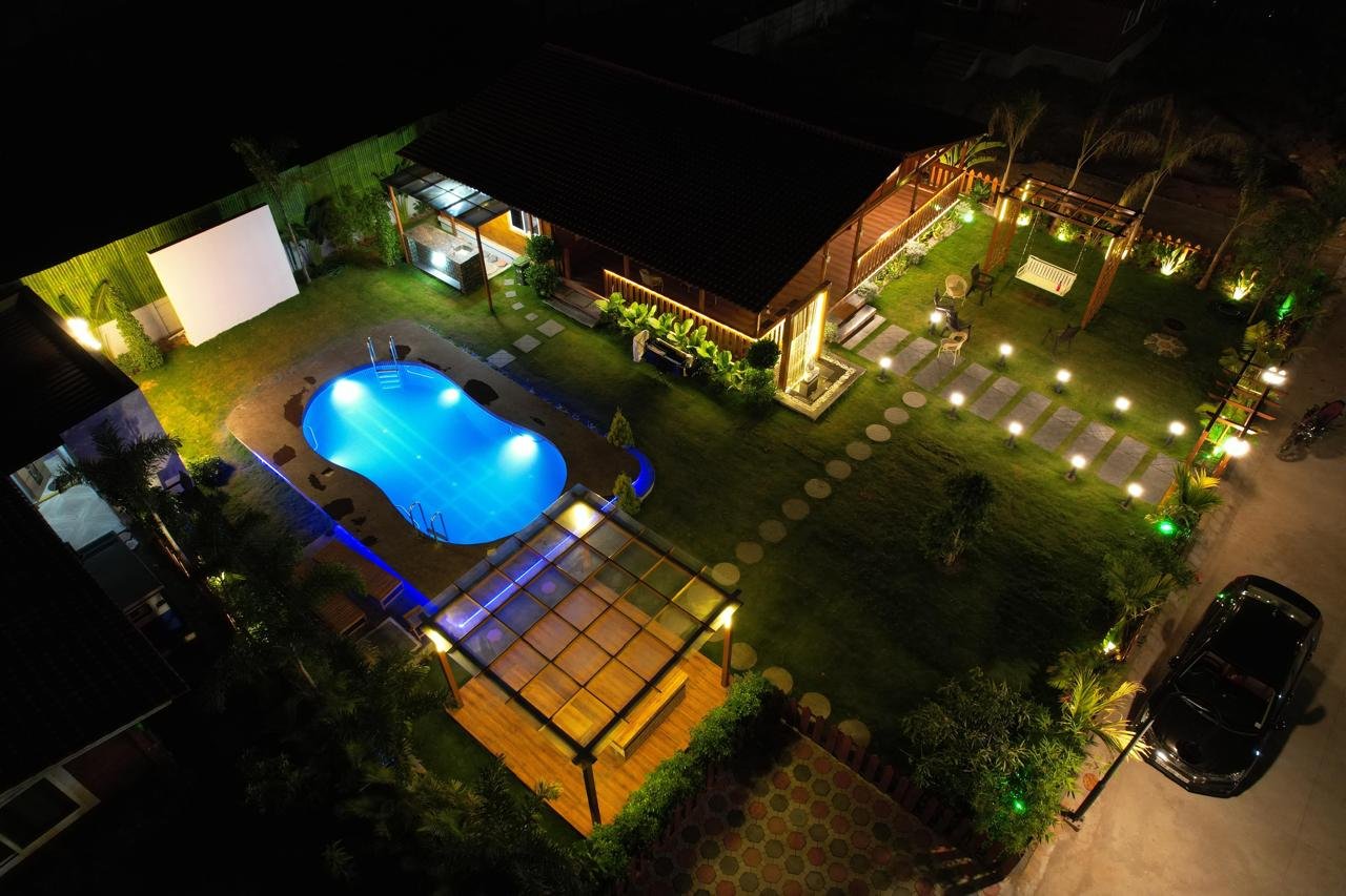 Aerial night view of La Cabana Farm Stay with pool and lawns